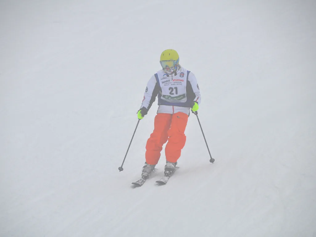 Skifahrer mit Startnummer 21 in oranger Hose.